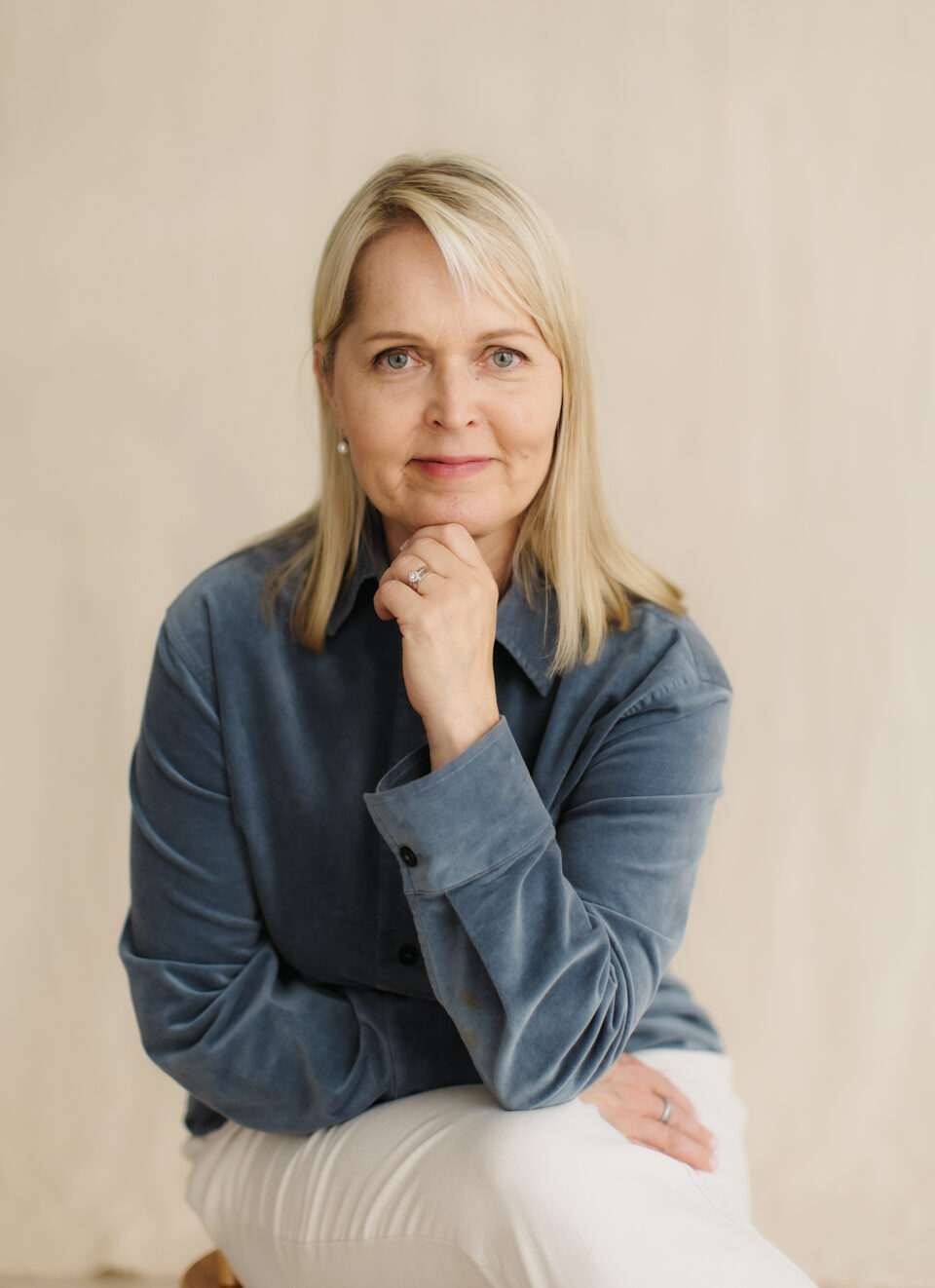 Päivi Karhu, uniterapeutti, istuu mietteliäänä käsi leuan alla.